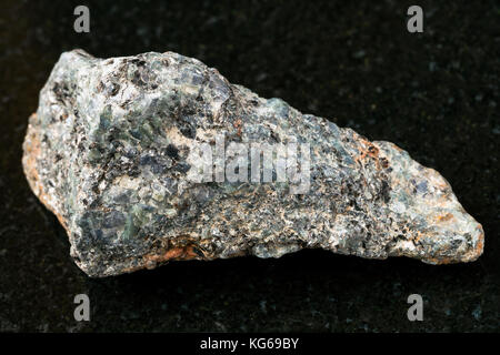 Makroaufnahmen von natürlichen Mineralgestein Muster - grobe Biotit nephelinsyenit Stein auf dunklem Granit Hintergrund Stockfoto