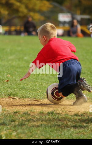 Kleiner Junge, ein Sturz auf den Fußballplatz Stockfoto