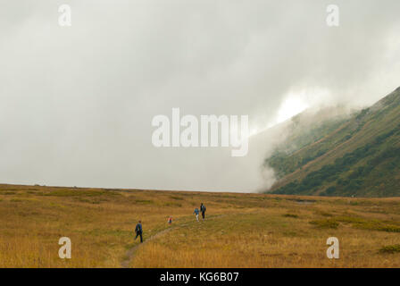 Russland, Krasnaja Poljana - 23. September 2017: Eine Gruppe von Touristen, Spaziergänge und ist in der alpinen Wiesen auf einem Hochplateau zwischen den Wolken fotografiert. Stockfoto