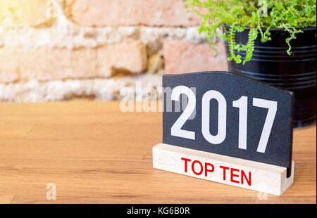 Neues Jahr 2017 Top ten Thema Nummer auf blackboard anmelden und grüne Pflanze auf Holz Tisch an der Wand. Stockfoto