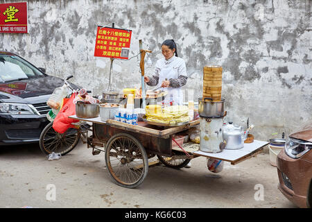 Lijiang, Yunnan, China - 27. September 2017: Frau bereitet und verkauft Frühstück essen von der Straße. Zahlung per QR-Code wird sehr häufig in Chi Stockfoto