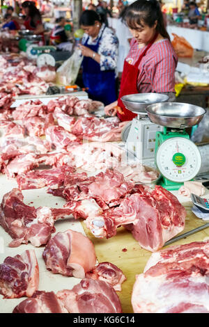 Lijiang, Yunnan, China - September 27, 2017: Frauen verkaufen frisches Fleisch auf der lokalen Fleischmarkt. Stockfoto