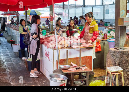 Lijiang, Yunnan, China - September 27, 2017: Der Kunde wählt frisches Fleisch auf dem lokalen Markt. Stockfoto
