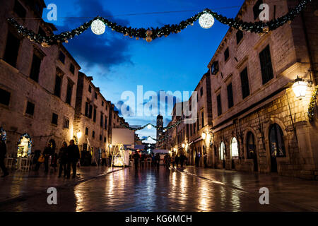 Dubrovnik, Kroatien - 31. Dezember 2015: stradun alte Straße mit Weihnachtsbeleuchtung und Ornamente in der Nacht mit Leuten herum Stockfoto