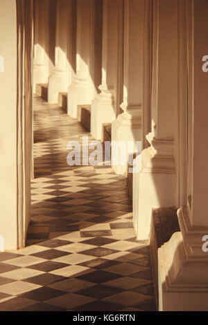 Warmes Sonnenlicht strahlt durch einen Balkon Haus auf dem Fliesenboden. abstrakt und Kunst Stockfoto