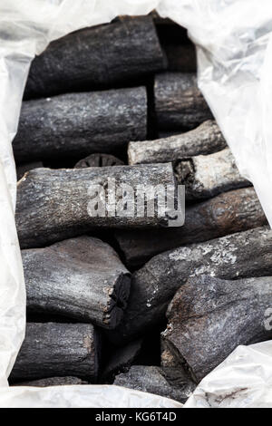 Natürliche Holzkohle in die Plastiktüte zum Verkauf bereit. Traditionelle Holzkohle oder Holz Kohle. Selektive konzentrieren. Stockfoto