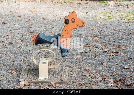 Stadt und öffentlicher Spielplatz mit einer Feder Rider mit tierischen Form im Vordergrund, Girona, Katalonien Stockfoto