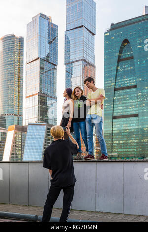 Moskau, Russland - November 2. 2017 Jugendliche werden im Hintergrund von einem Wolkenkratzer der Stadt Moskau fotografiert. Stockfoto