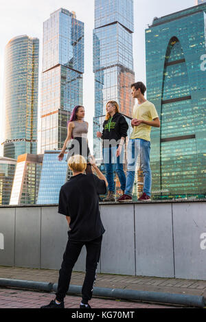 Moskau, Russland - November 2. 2017 Jugendliche werden im Hintergrund von einem Wolkenkratzer der Stadt Moskau fotografiert. Stockfoto