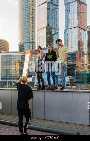 Moskau, Russland - November 2. 2017 Jugendliche werden im Hintergrund von einem Wolkenkratzer der Stadt Moskau fotografiert. Stockfoto