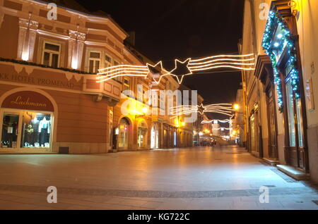 Weihnachtsbeleuchtung in der leeren Fußgängerzone in der Stadt Györ Stockfoto