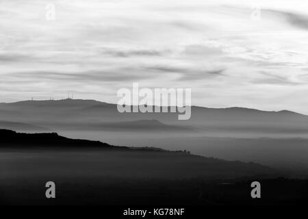 Ein Tal von Nebel bei Sonnenuntergang, gefüllt mit verschiedenen Schichten aus Hügeln und Bergen und sanften Farbtönen Stockfoto