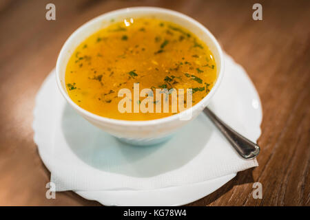 Hühnersuppe mit Nudeln und Gemüse, die in weiße Schüssel Stockfoto