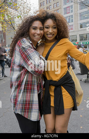 Eine schöne Mutter (l) und Tochter, die wie Schwestern aussehen Pose liebevoll in Union Square Park in Manhattan, New York City. Stockfoto