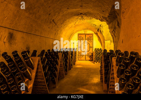 Reims, Frankreich - 12. Juni 2017: die Grotten von Champagner Haus taittinger mit alten Flaschen Champagner in Pupitres und Tür des alten Klosters, Frankreich. Stockfoto