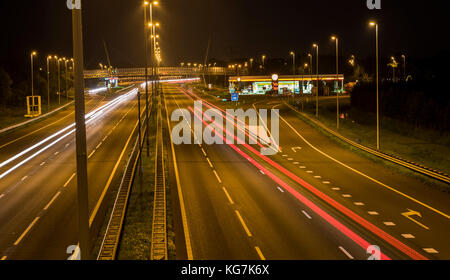 Woudenberg, Niederlande - 21 August 2017: Autobahn in der Nacht mit Autos mit weißen und roten Ampeln vorbei und eine Tankstelle, Niederlande. Stockfoto