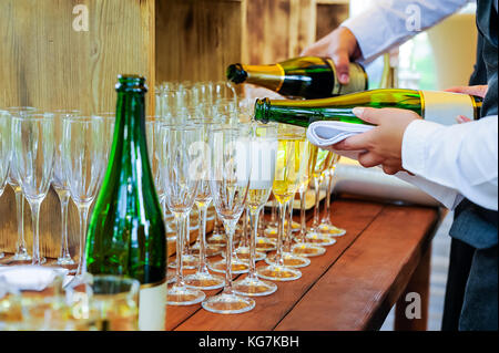 Kellner gießen Persönliche serviert Champagner Gläser. Catering bei Veranstaltungen, Treffen, Party, Hochzeiten. selektive Fokus, Platz für Text. Stockfoto