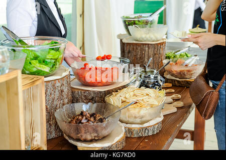 Outdoor Küche kulinarische Salat bar Catering. Gruppe von Menschen im All you can eat.Speisen essen Feier party Konzept. service Business Meeting, w Stockfoto