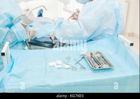 Nahaufnahme der zahnärztlichen Chirurgie Prozess - Implantation. Zahnarzt Chirurg mit Assistant in der modernen Klinik. Stomatologie und Health Care Konzept. Selektive konzentrieren. Stockfoto