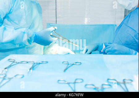 Nahaufnahme, Hände eines Chirurgen und ein Assistent mit Instrumenten während der Chirurgie der Bauchhöhle. selektive Fokus, Platz für Text. Stockfoto