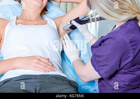 Bis Laser Haarentfernung im Beauty Salon schließen. Frau, die Achseln epilieren. Selektive konzentrieren. Stockfoto