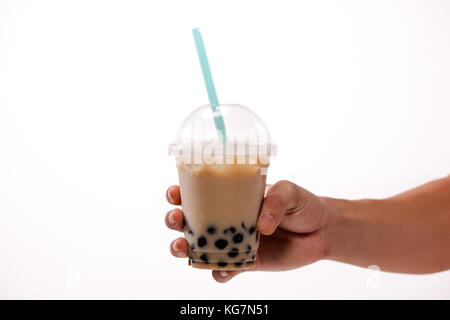 Hand, die Pearl Milch Kaffee auf weißem Hintergrund Stockfoto
