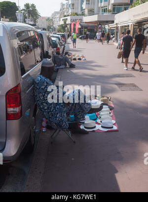 Mann auf der Straße verkaufen sunhats, Cannes, Côte d'Azur, Provence-alpes-côte d'Azur, Frankreich. Stockfoto