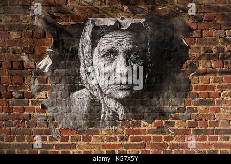 Rip-paste-up Street Art von eine ältere Frau auf eine Mauer in Camden Town, London, UK. Stockfoto