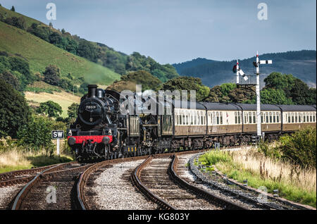 Eine Dampflokomotive rundet eine Schlaufe, da es Ansätze corwen Station auf der Llangollen Railway in Nord Wales Stockfoto