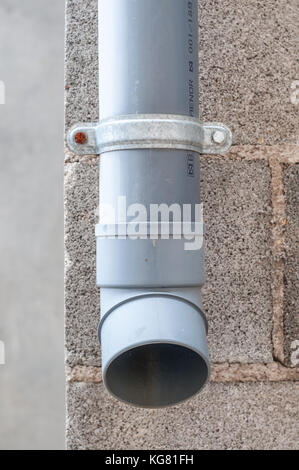 Industrielle Wasser ablassen PVC-Rohr mit Betonklotz im Hintergrund Stockfoto