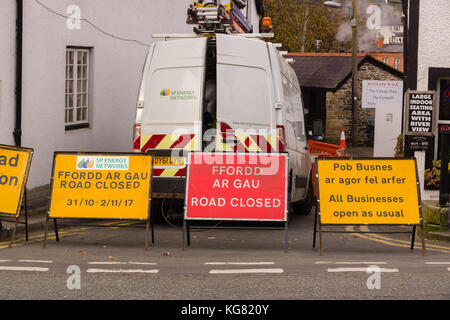 Zweisprachige Schilder in Englisch und Walisisch an temporären Straße und Bürgersteig arbeitet mit einem SP Energienetze Fahrzeug blockieren Dee Lane in Llangollen Wales Stockfoto