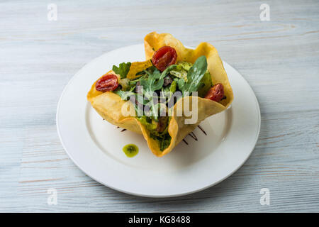 Salat mit Rindfleisch, Leber und Mango in den Kuchen auf eine weisse Platte Stockfoto