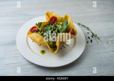 Salat mit Rindfleisch, Leber und Mango in den Kuchen auf eine weisse Platte Stockfoto