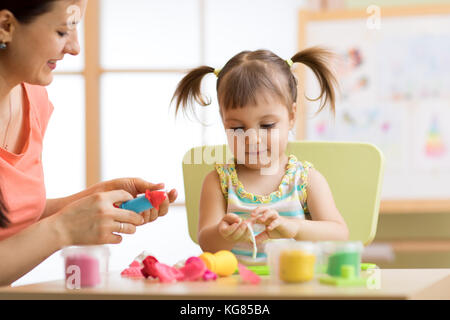 Mutter und Kind Tochter zu Hause aus Ton geformt und zusammen spielen. Konzept der Vorschule oder Home Bildung. Stockfoto