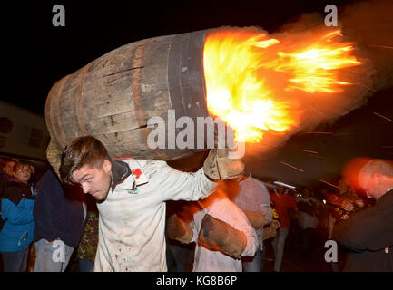 Die Teilnehmer laufen mit einer brennenden Fass im Teer bei der jährlichen Ottery St Mary tar barrel Festival in Devon getränkt, uk Credit: finnbarr Webster/alamy leben Nachrichten Stockfoto