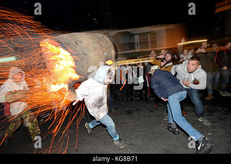 Die Teilnehmer laufen mit einer brennenden Fass im Teer bei der jährlichen Ottery St Mary tar barrel Festival in Devon getränkt, uk Credit: finnbarr Webster/alamy leben Nachrichten Stockfoto