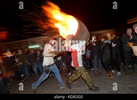 Die Teilnehmer laufen mit einer brennenden Fass im Teer bei der jährlichen Ottery St Mary tar barrel Festival in Devon getränkt, uk Credit: finnbarr Webster/alamy leben Nachrichten Stockfoto