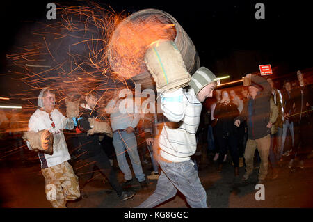 Die Teilnehmer laufen mit einer brennenden Fass im Teer bei der jährlichen Ottery St Mary tar barrel Festival in Devon getränkt, uk Credit: finnbarr Webster/alamy leben Nachrichten Stockfoto