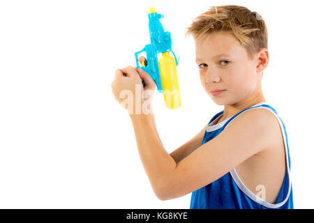 Pre-teen Junge spielt mit Wasserpistolen auf weißem Hintergrund Stockfoto