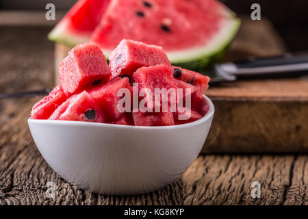 Wassermelone. Wassermelone in Schüssel auf Holztisch geschnitten. Stockfoto