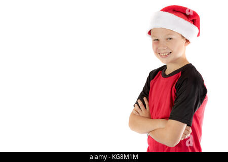 Pre-teen Boy trägt eine Weihnachtsmütze looiking glücklich isoliert auf weiss Stockfoto