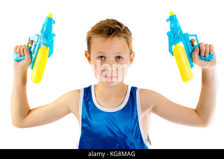 Pre-teen Junge spielt mit Wasserpistolen auf weißem Hintergrund Stockfoto