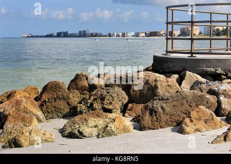 Felsen am Strand am Ende von einem Betonpfeiler, die in den Golf von Mexiko, Madeira Beach, Florida, USA ragt Stockfoto