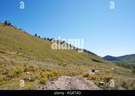 Malerische Berglandschaft mit einem 4WD Fahrzeug entlang einer schmalen Feldweg ich den Abstand auf einem schönen sonnigen Tag Stockfoto