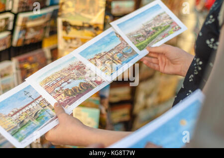 Mädchen wählen Postkarte in Italien Stockfoto