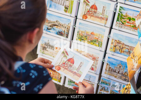 Mädchen wählen Postkarte in Italien Stockfoto