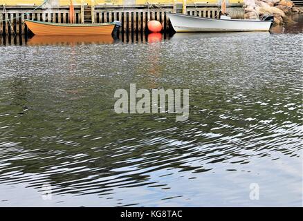 Boote gebunden an der Pier, Petty Harbour, Neufundland Labrador. Bild meist Wasser die Oberfläche mit Boote und Pier an der Oberseite des Bildes. Stockfoto