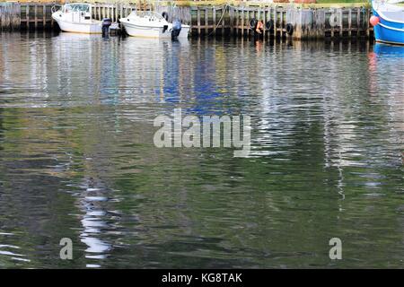 Boote gebunden an der Pier, Petty Harbour, Neufundland Labrador. Bild meist Wasser die Oberfläche mit Boote und Pier an der Oberseite des Bildes. Stockfoto