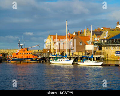 Whitby Hafen mit der Rettungsbootstation, zwei festverankerten Vergnügungssegelbooten und dem Abbey Wharf Restaurant im Herbstsonnenlicht Stockfoto