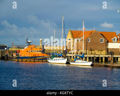 Whitby Hafen mit dem Rettungsboot Station und zwei günstig Vergnügen Segelboote im Herbst Sonnenlicht Stockfoto